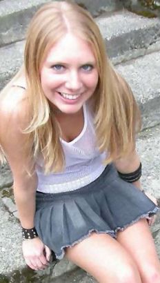 Bashful girl wearing a skirt so short she can't hide her lack of panties.  She stuffed what little fabric she can between her legs in a desperate attempt to hide her pussy.